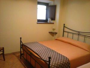 Un dormitorio con una cama con una colcha naranja y una ventana. en Agriturismo Valiana, en Montegabbione