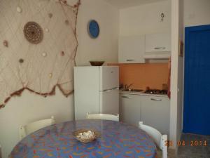 a small kitchen with a table and a refrigerator at La casetta 5P in Santa Flavia