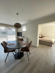 a living room with a table and chairs and a bed at Vakantie Studio Mari Jani in Waterlandkerkje