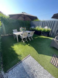 a patio with a table and two chairs and an umbrella at Vakantie Studio Mari Jani in Waterlandkerkje