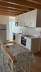 a kitchen with a table and a kitchen with white cabinets at casa 20 centro in Lagos