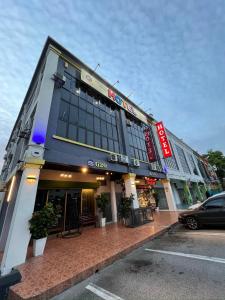 a building with a car parked in front of it at Ghazrins Garuda Hotel in Johor Bahru