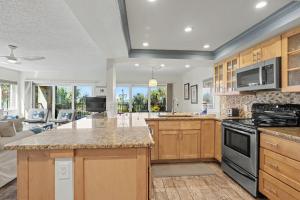 a large kitchen with wooden cabinets and a living room at Land's End 8-301 Beach Front in St. Pete Beach