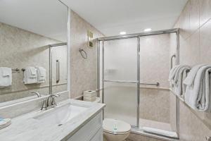 a bathroom with a shower and a sink and a toilet at Land's End 8-301 Beach Front in St. Pete Beach +41 photos
