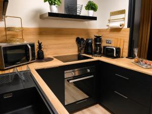a kitchen with a counter with a microwave and a sink at SUITE KASSIOPEE, romantisme, balnéo, sauna in Quimperlé