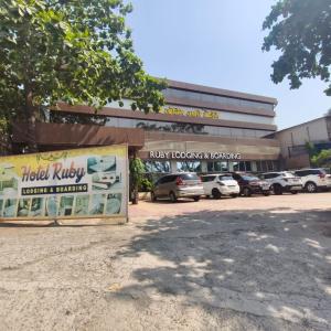 a building with cars parked in a parking lot at Ruby Lodging And Boarding in Mangrul +21 photos