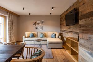 a living room with a couch and a tv at Alpbach Lodge Chalet Superior in Alpbach