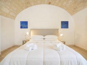 a large white bed in a white room with two lamps at Palazzo Della Tore 001-Elegant Historic Escape in Torre a Mare
