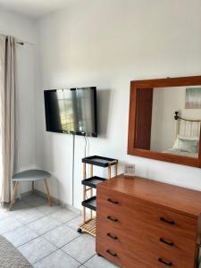 a room with a dresser and a television on a wall at Annalisa Studio & Apartments in Skala