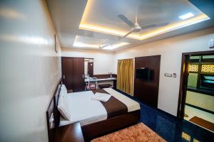 a hotel room with a bed and a ceiling at V V Residency in Thanjāvūr
