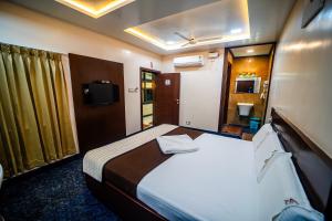 a hotel room with a bed and a television at V V Residency in Thanjāvūr +37 photos
