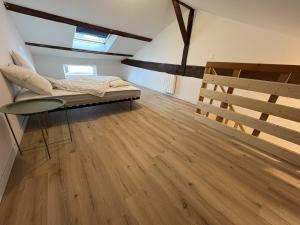 a bedroom with a bed and a wooden floor at LONI Expériences moderne emplacement idéal in Challans