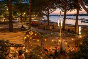 a group of people sitting at tables in a park at night at Bel appart vue lac in La Grande Motte