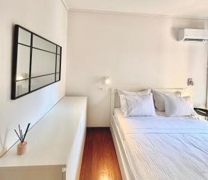 a white bedroom with a bed and a window at Blue Cozy Nest in Rhodes Town +10 photos