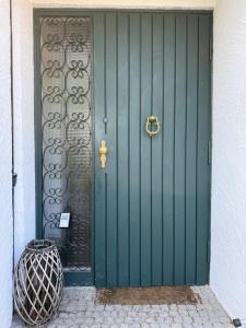 a green door with a gold knocker on it at Apartment Ammersee in Dießen am Ammersee