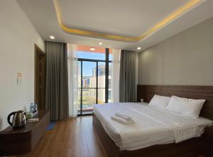 a bedroom with a large bed with a large window at MeySunset Hotel Phu Quoc in Phú Quốc +73 photos