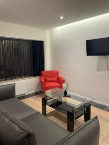 a living room with a couch and a red chair at Coquille in Nieuwpoort