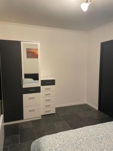 a bedroom with a bed and a dresser and a mirror at Coquille in Nieuwpoort