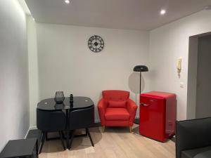 a living room with a red chair and a table at Coquille in Nieuwpoort