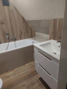 a bathroom with a sink and a bath tub at Pod skosem in Witów +3 photos