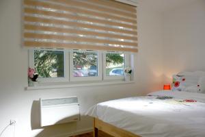- une chambre avec un lit et une fenêtre avec des stores dans l'établissement Apartment Lejla, à Sarajevo