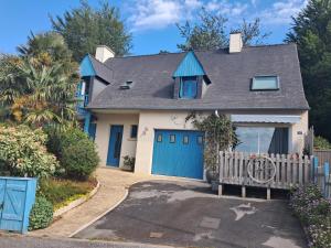 a house with blue doors and a fence at Duplex du Bois d'Amour in Quimper