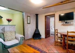a living room with a fireplace and a table at Sacred Mountain Lodge in Noordhoek