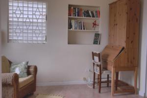 a living room with a piano and a chair at Mermaid Apartments in Saint Philip