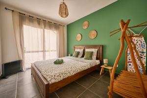 a bedroom with a bed and a green wall at Le Clos des Remparts - 8 pers - Cascades & Nature in La Plaine des Palmistes