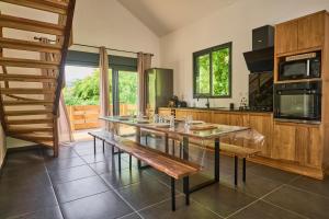 a kitchen with a wooden table and a bench at Le Clos des Remparts - 8 pers - Cascades & Nature in La Plaine des Palmistes