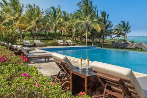 a pool with a bunch of chairs and a table at Zawadi Hotel, Zanzibar in Michamvi
