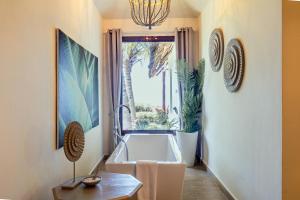 a bathroom with a bath tub and a window at Zawadi Hotel, Zanzibar in Michamvi