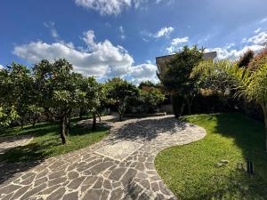 a stone walkway in a yard with trees at Villa Chiara in Piscopio