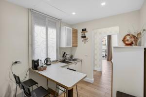 a white kitchen with a counter and chairs in it at Pompei Luxury Suites-Near Ruins in Pompei