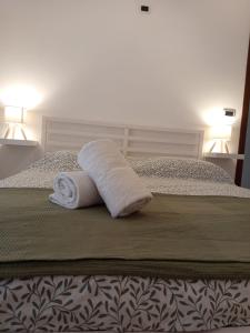 a pair of towels sitting on a bed at Riflessi nosTrani - Seaside Rooms in Trani