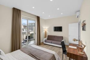 a bedroom with a bed and a desk and a couch at Pompei Luxury Suites-Near Ruins in Pompei
