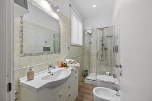 a white bathroom with a sink and a shower at Pompei Luxury Suites-Near Ruins in Pompei +47 photos