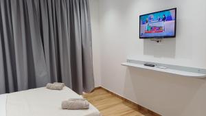 a room with a bed and a flat screen tv at Irene's rooms in Himare
