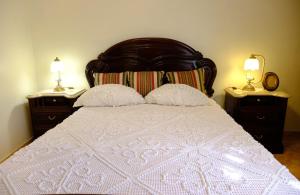 a bedroom with a white bed with two night stands at Gods Barn House in Viana do Castelo +8 photos