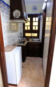 a kitchen with a white refrigerator and a sink at Gods Barn House in Viana do Castelo