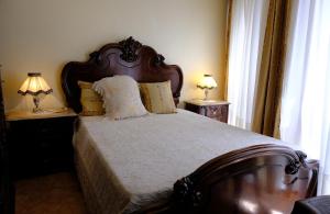 a bedroom with a large bed with two lamps on tables at Gods Barn House in Viana do Castelo
