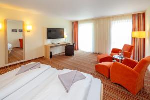 a hotel room with a large bed and a television at Hotel Gierer in Wasserburg