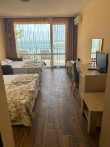 a hotel room with two beds and a desk with a computer at Villa Maria 2 in Chernomorets