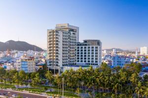 a city skyline with tall buildings and palm trees at Fleur de Lys Hotel Quy Nhon in Quy Nhon