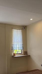 a room with a window with a curtain and a shelf at Ayu Homestay - Room 3 in San Isidro
