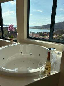 a bath tub with two wine glasses and a bottle at O NAUTICO suites in Cabana de Bergantiños