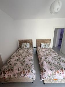 two beds sitting next to each other in a bedroom at Luxurious seaside apartment in Sakës