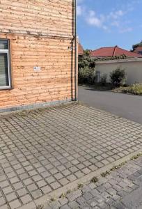 a house with a brick wall and a driveway at Ferienwohnung Mimi in Wernigerode