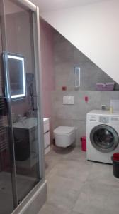 a bathroom with a sink and a washing machine at Apartament Monika Rewal z widokiem na morze in Rewal +11 photos