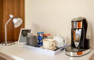 a counter with a coffee maker and cups on it at Sequoia Tree in Belfast